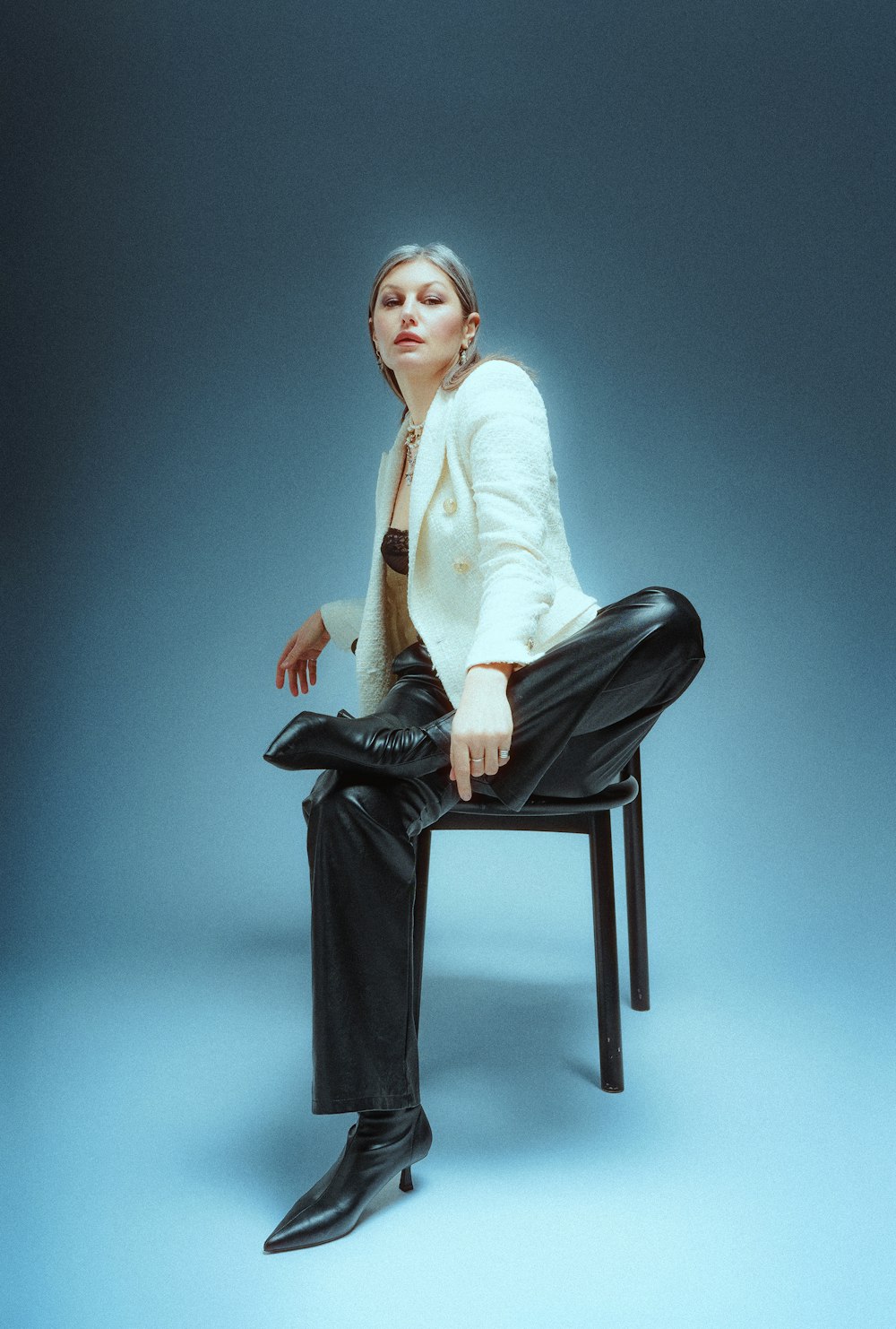 a woman sitting on a chair with her legs crossed