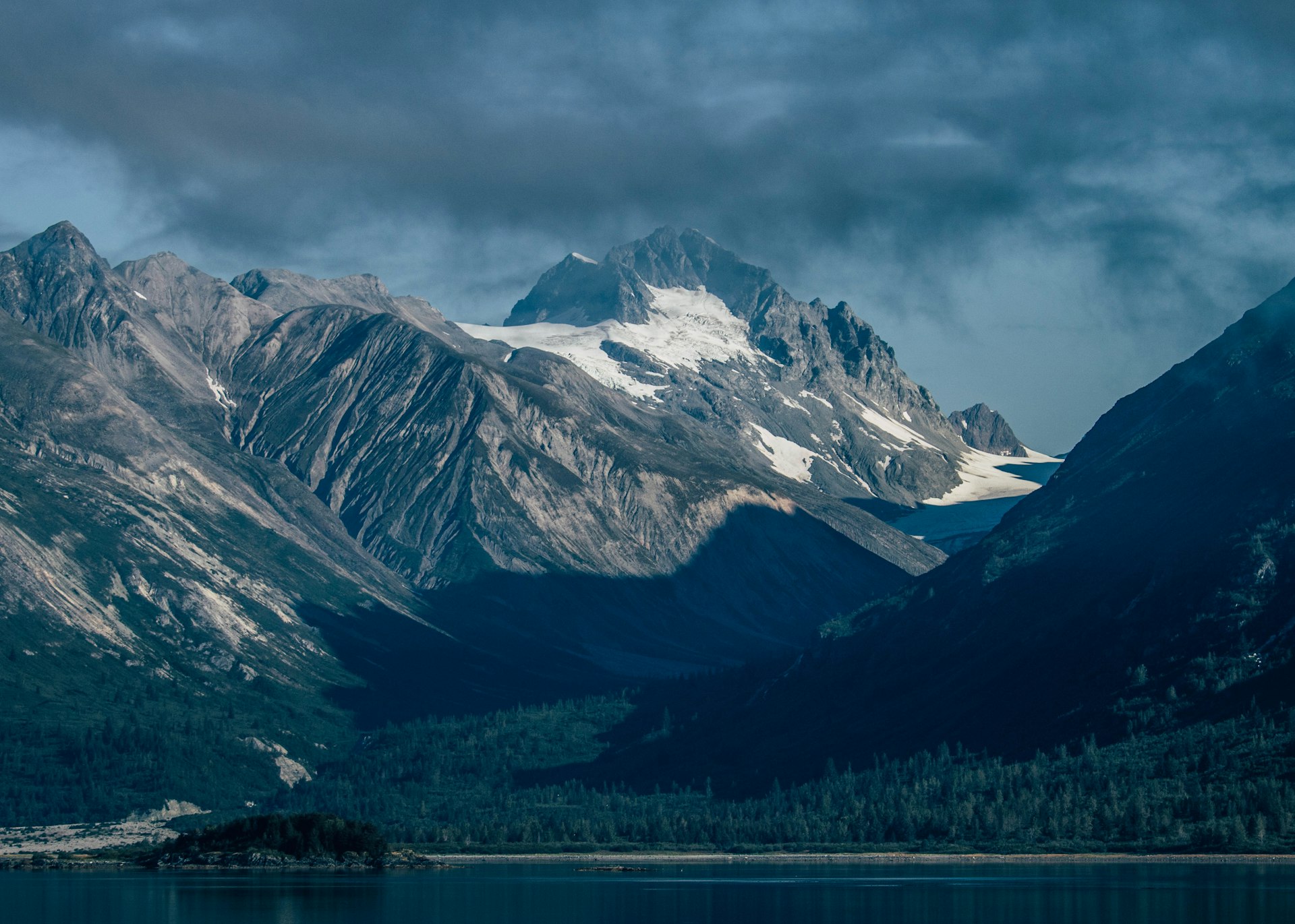 Alaska glacier landscape with mountain peaks and deep blue water