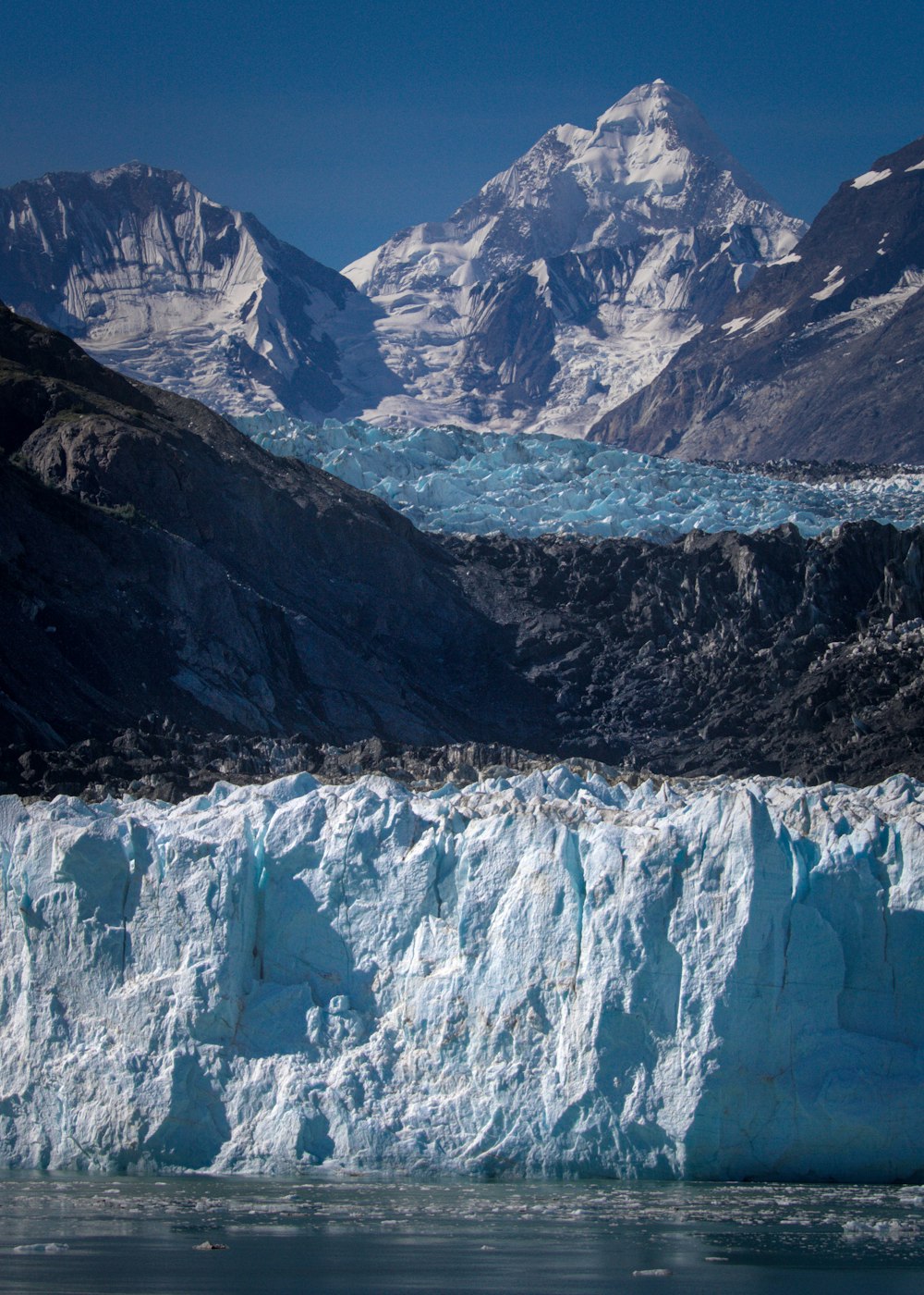 a large iceberg with mountains in the background