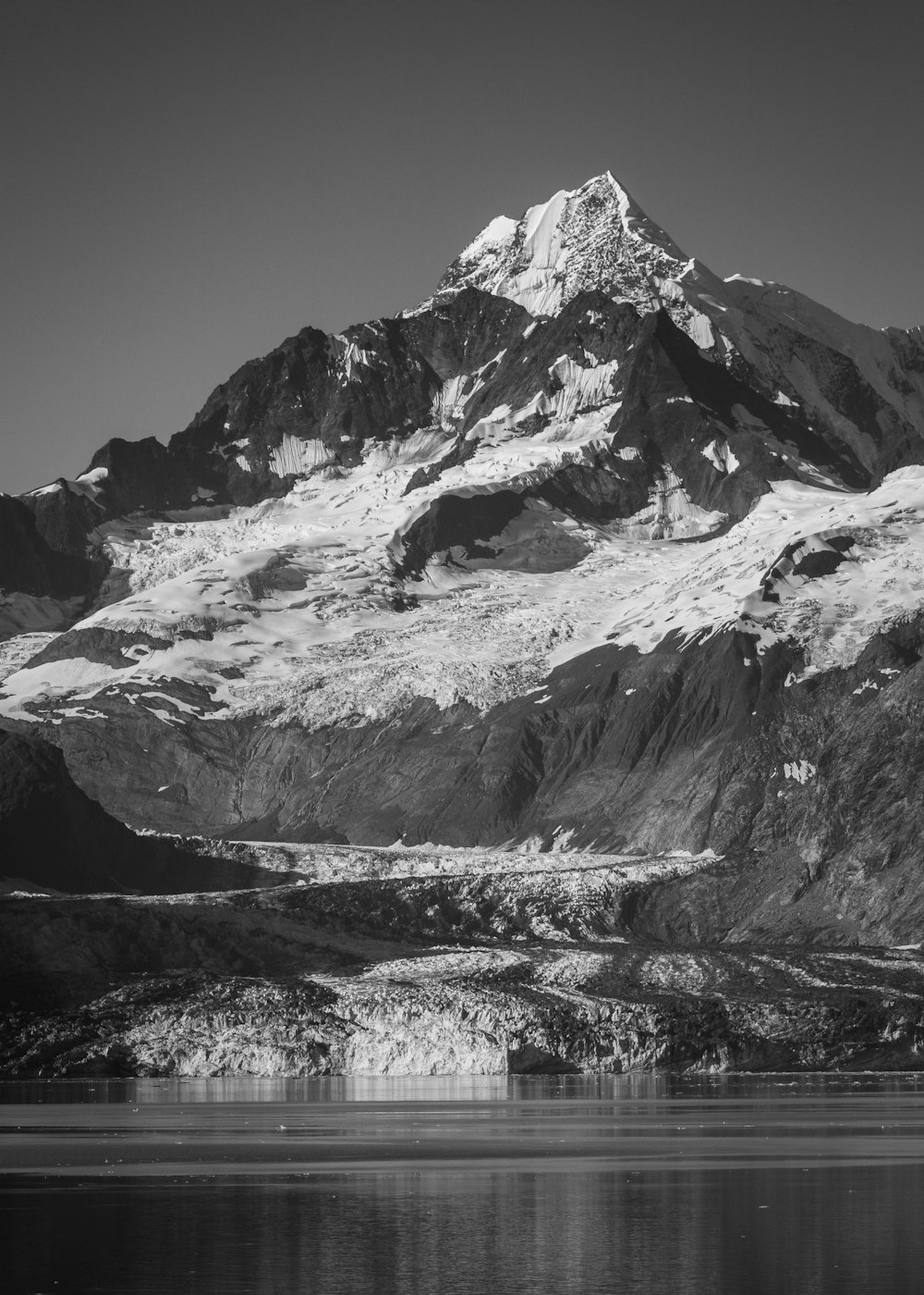 a snow covered mountain with a lake in front of it