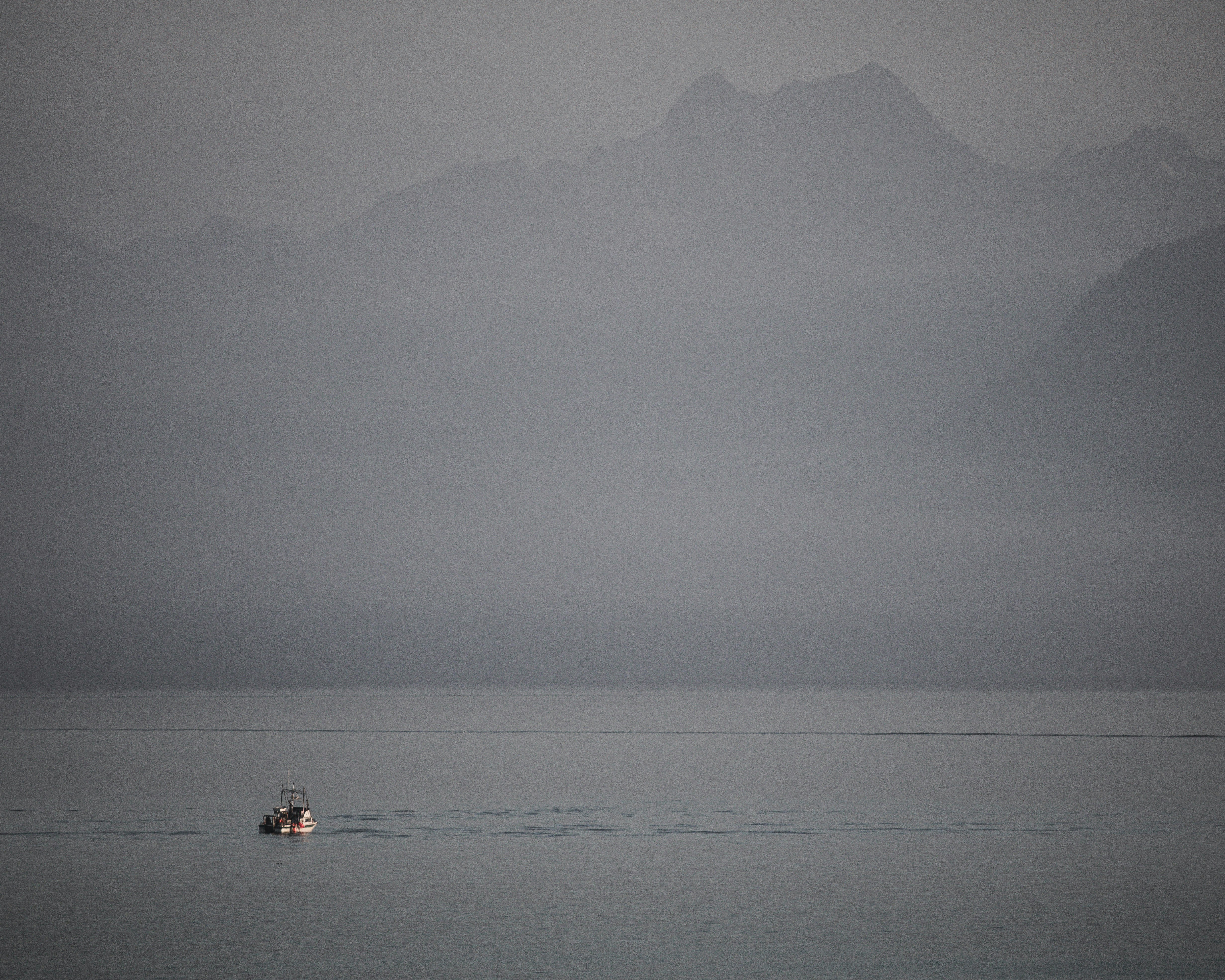 un pequeño bote en medio de un gran cuerpo de agua