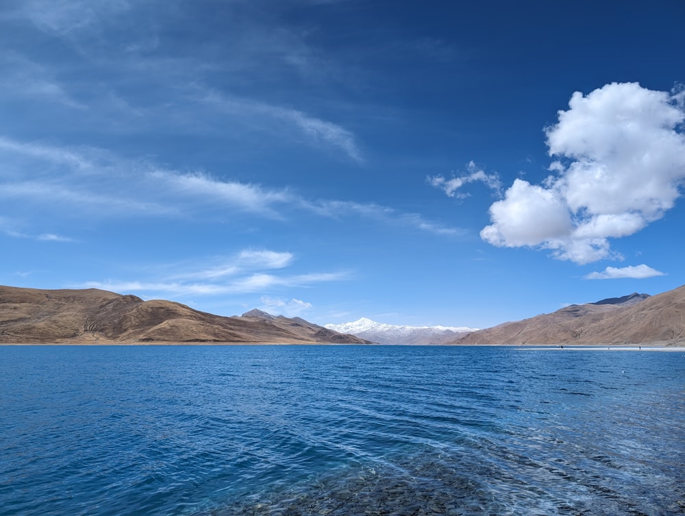 a body of water with mountains in the background