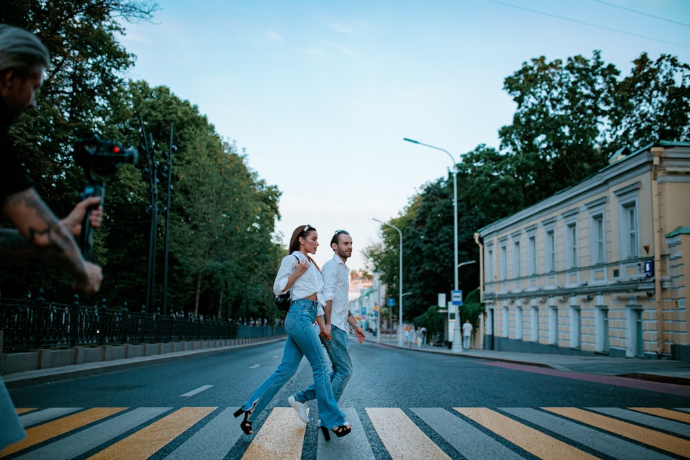 a couple of people that are walking across a street