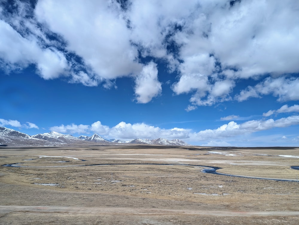 a wide open field with mountains in the background