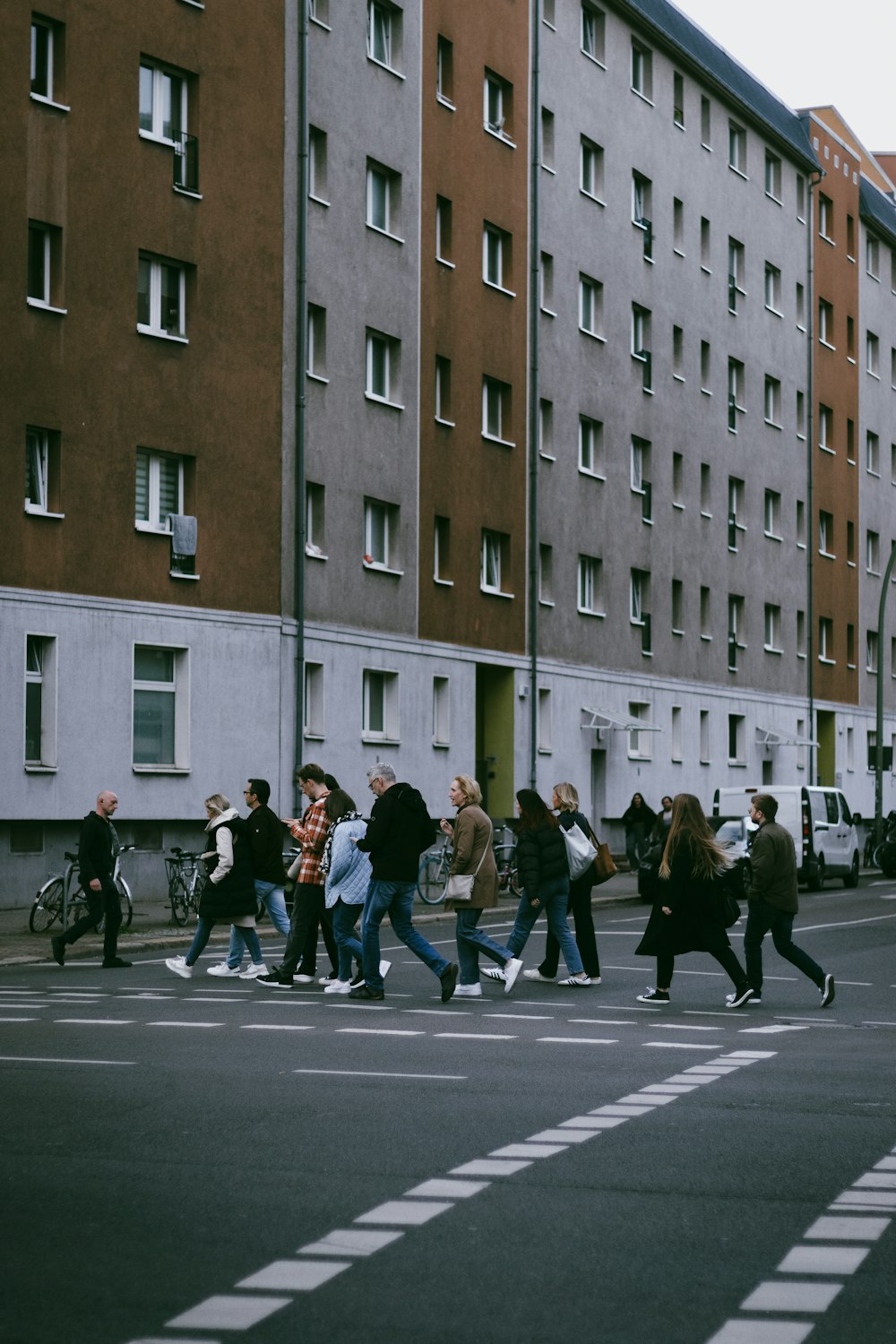 a group of people walking across a street