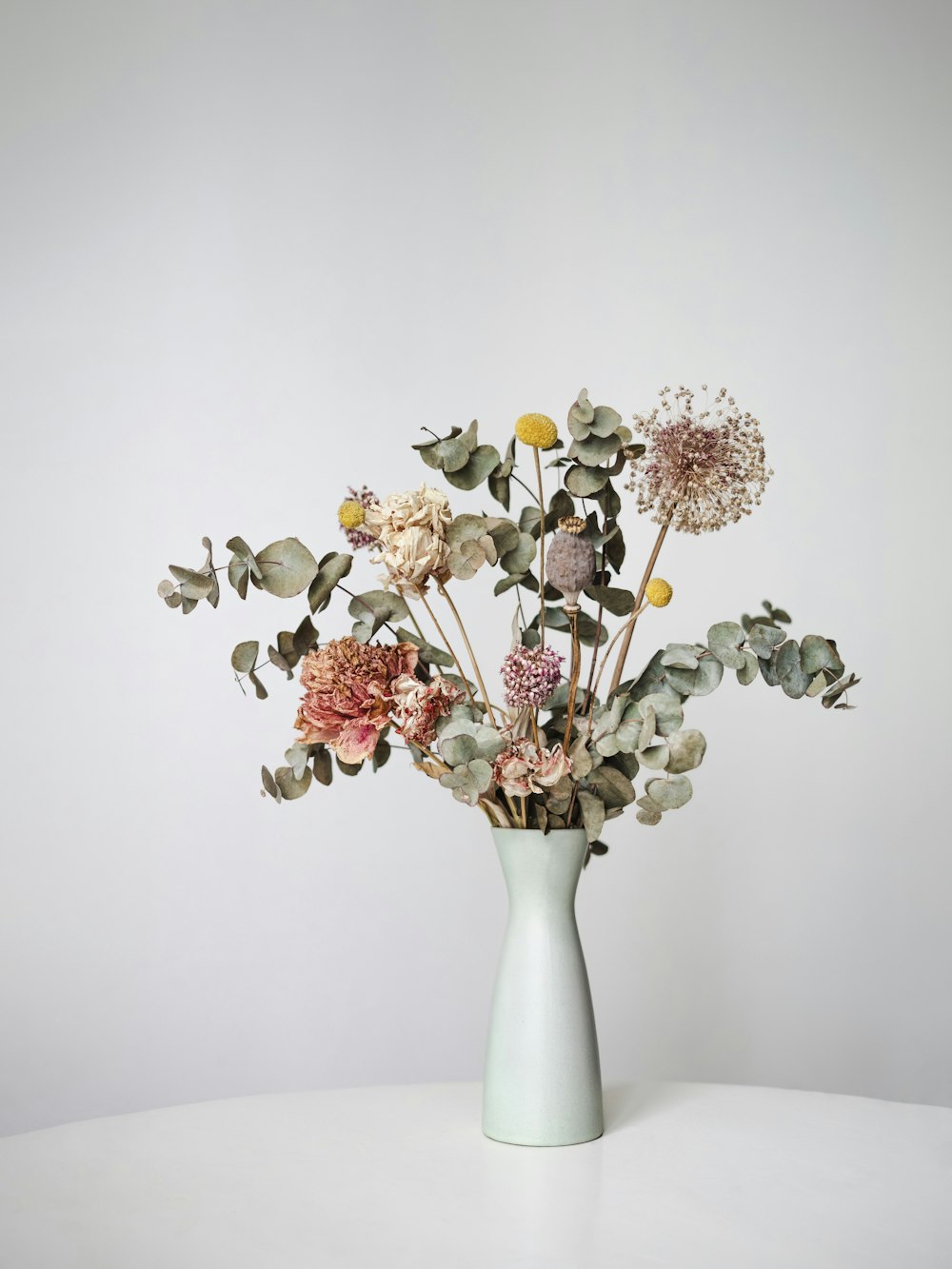 a vase filled with lots of flowers on top of a table