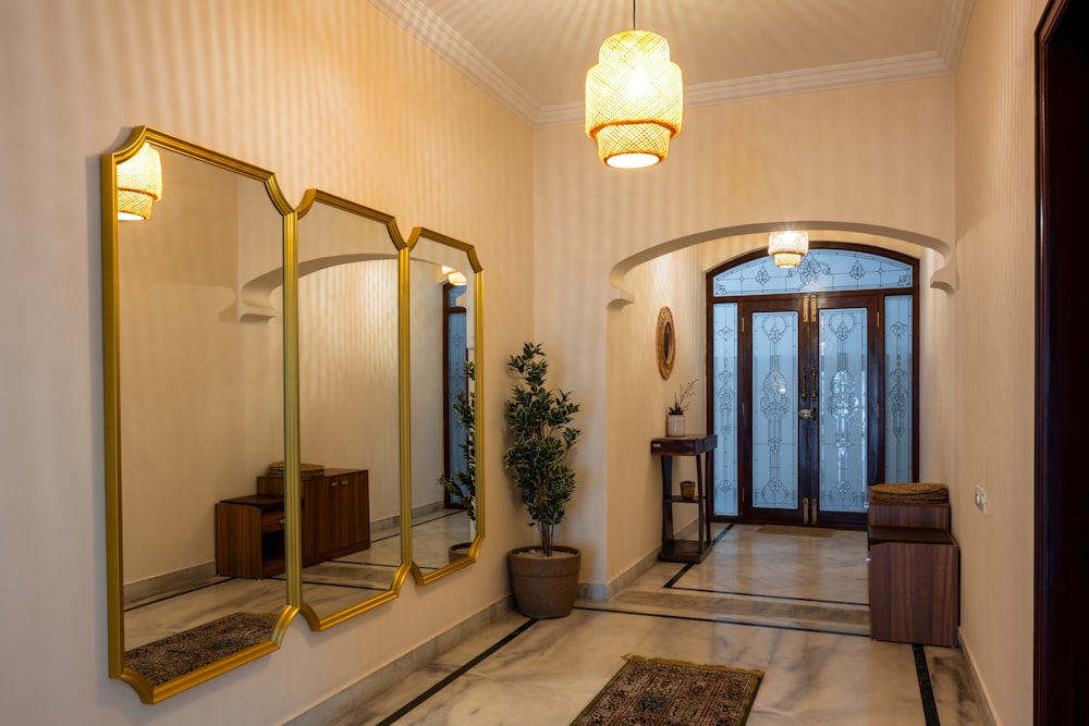 a hallway with three mirrors and a potted plant