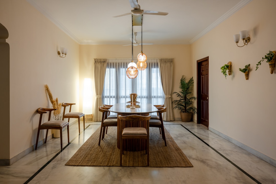 Warmly lit modern dining area in an apartment with wooden furniture and pendant lighting, evoking the mood of natural wood lamps in an urban Indian home