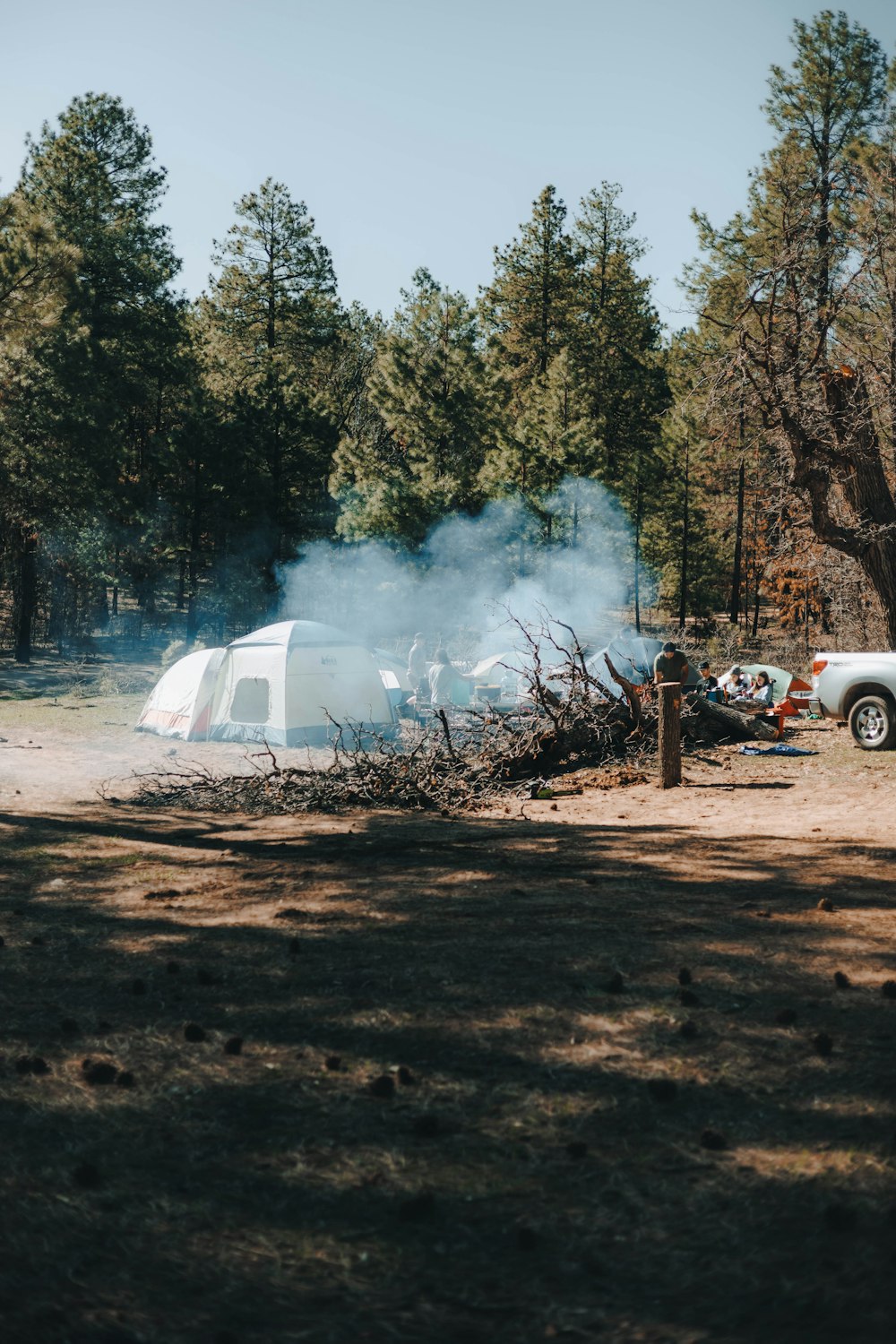 a camper is set up in the woods with smoke coming out of it