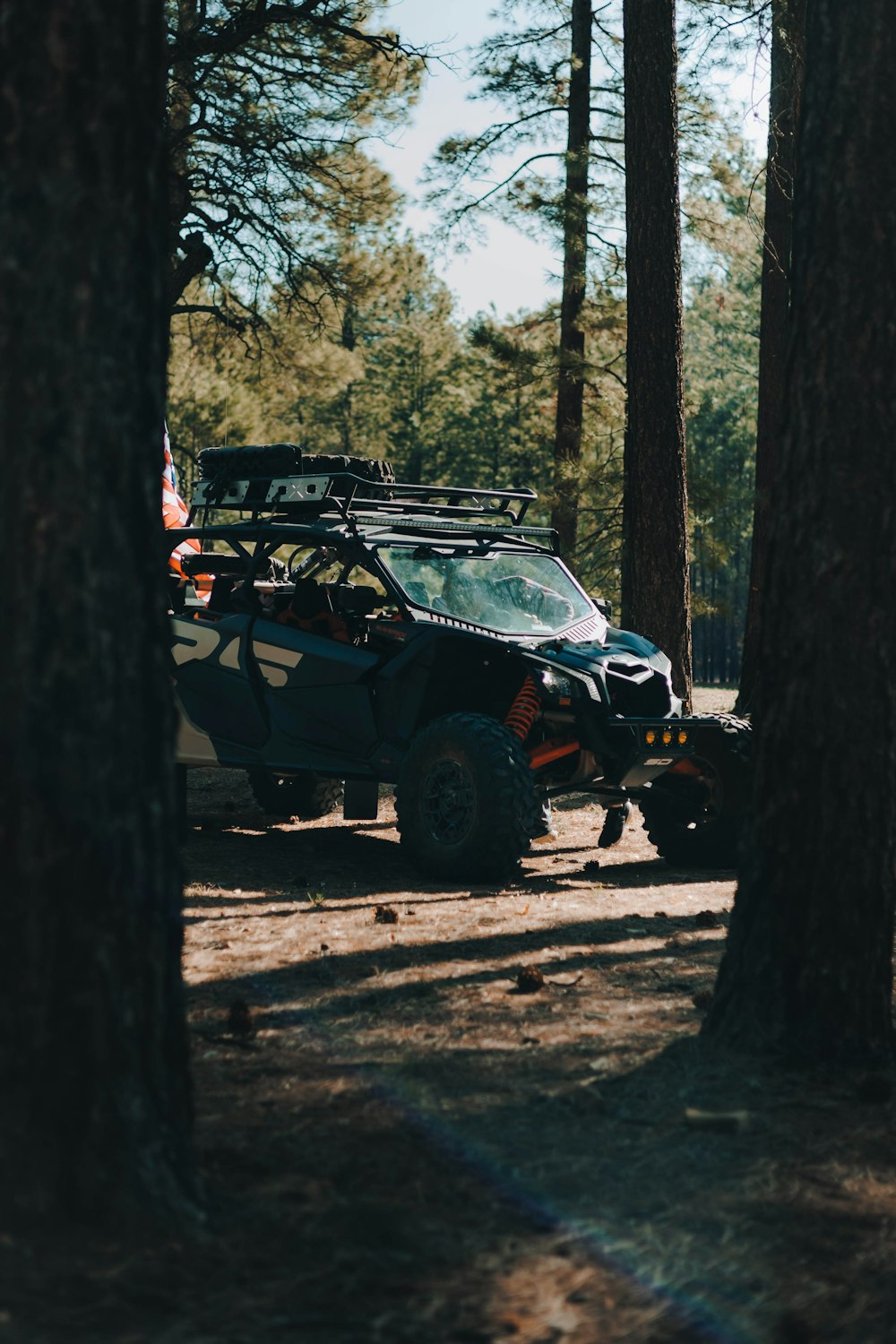 a vehicle parked in the middle of a forest
