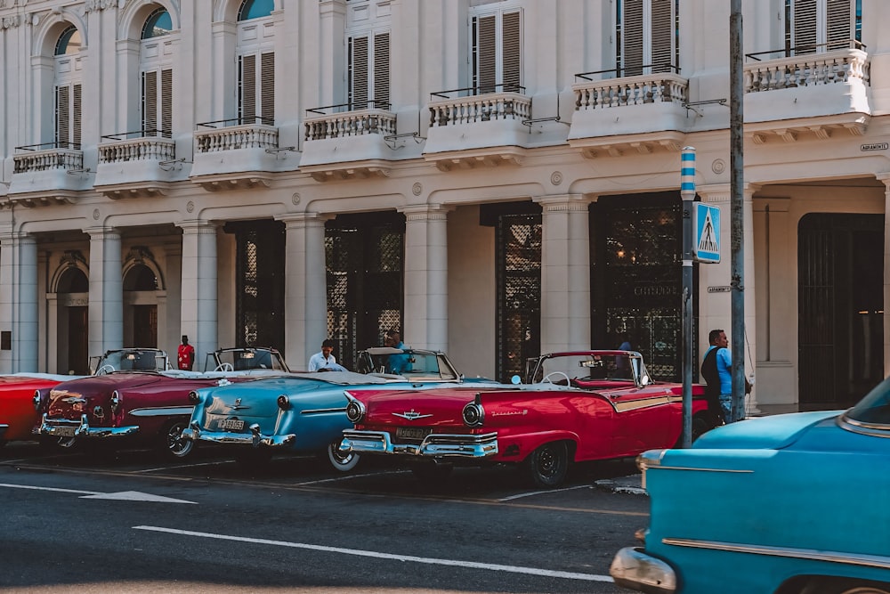 a row of classic cars parked in front of a building