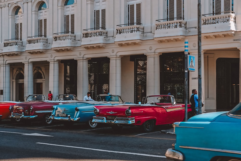 una fila di auto d'epoca parcheggiate davanti a un edificio