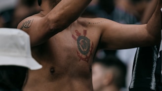 A shirtless man holding a cell phone to his ear