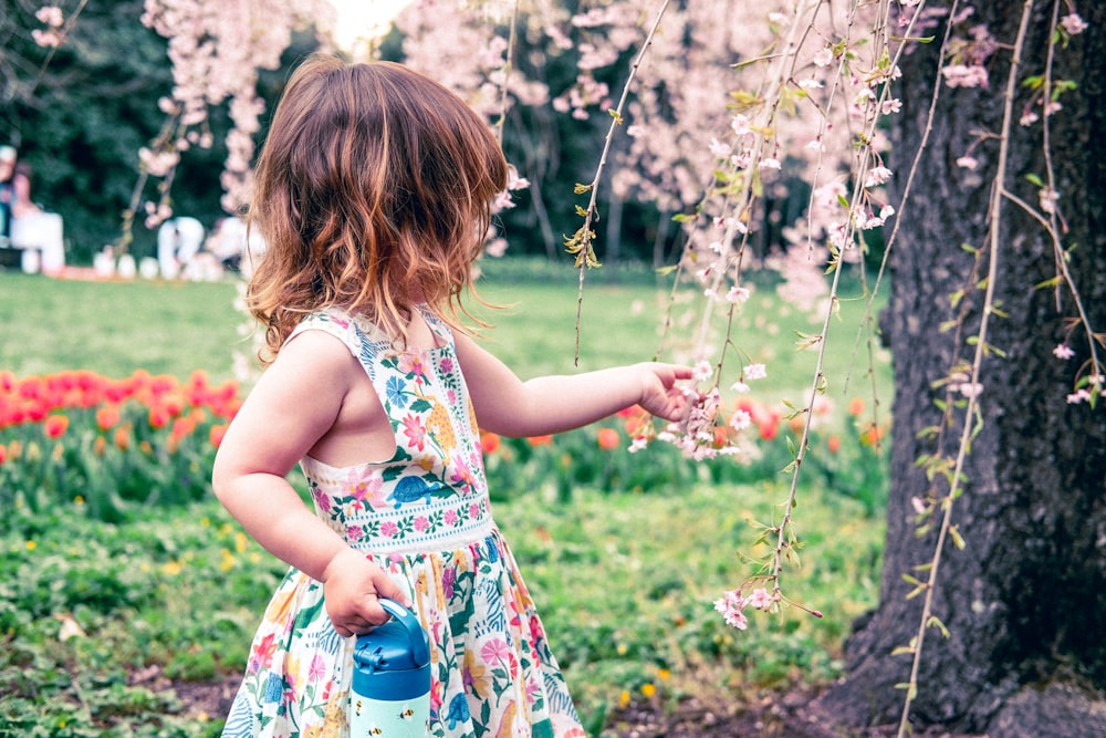 a little girl standing in a field of flowers