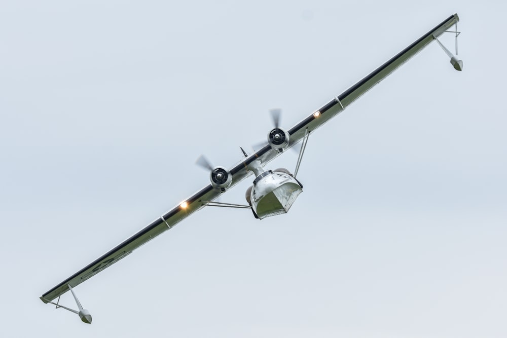 a small propeller plane flying through a blue sky