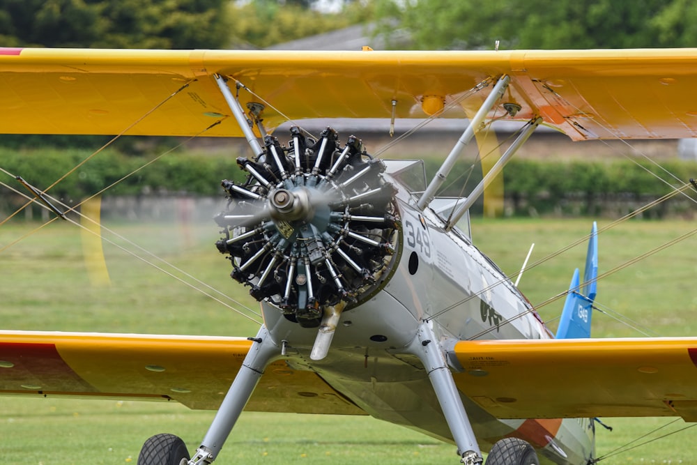 a small airplane with a propeller on a grassy field