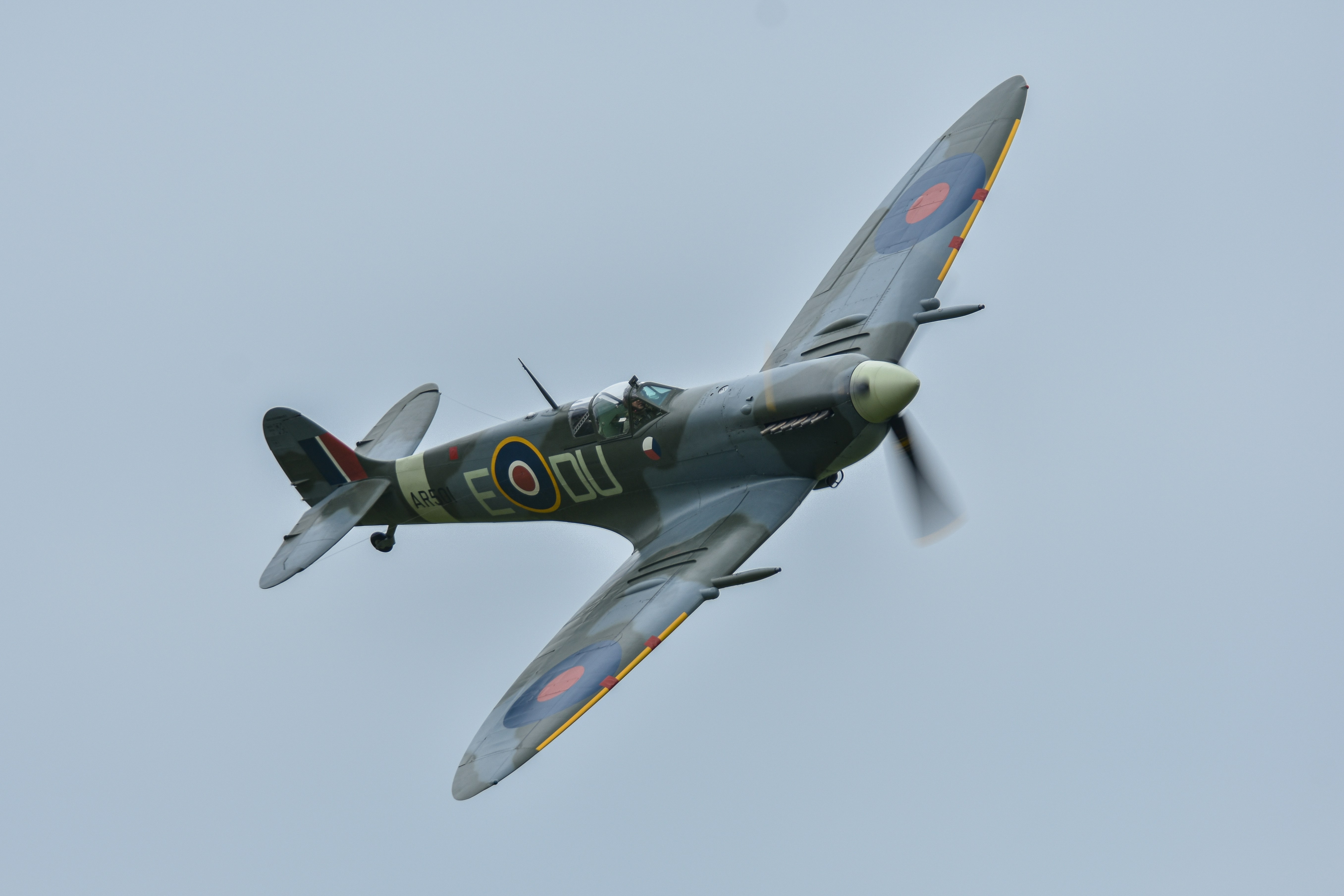 a small airplane flying through a cloudy sky, Supermarine Spitfire