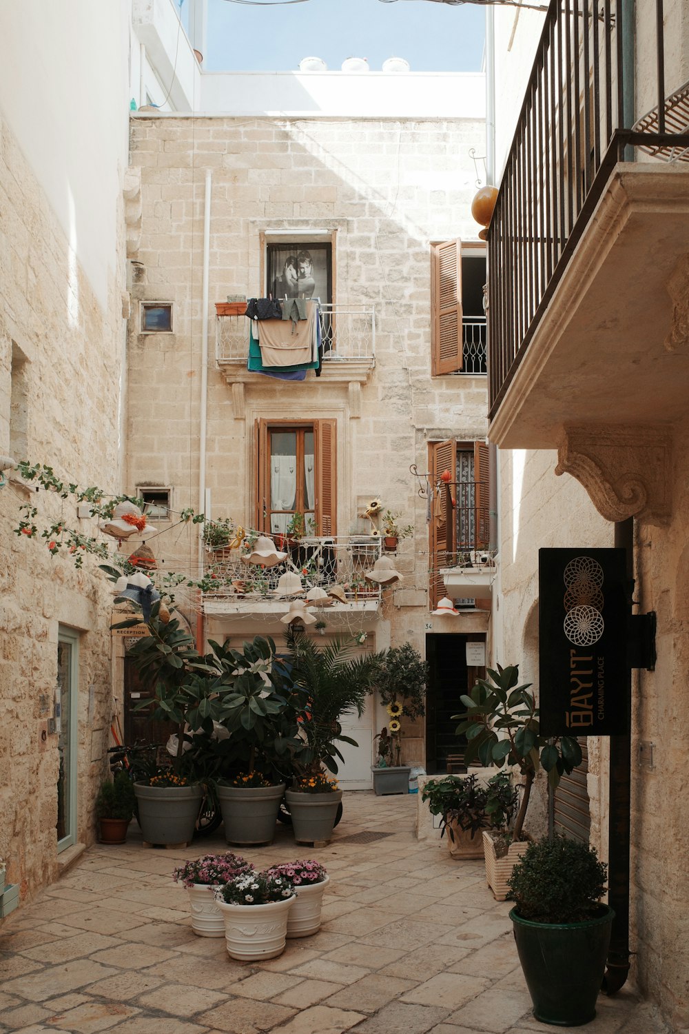 a courtyard with potted plants and a balcony