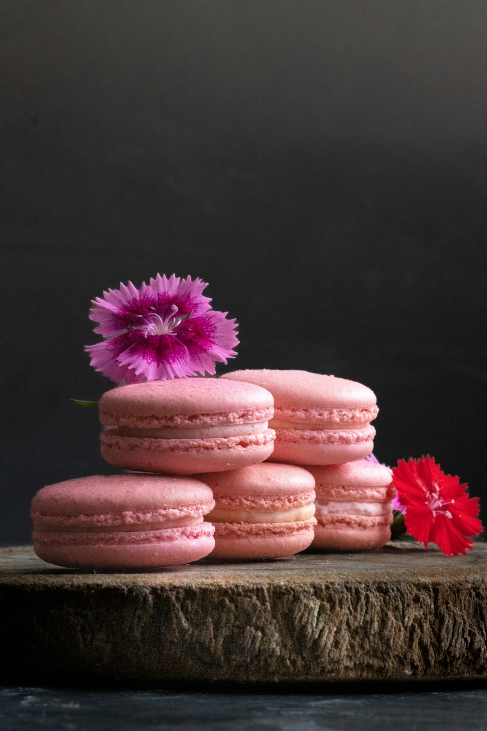 a stack of pink macaroons with a pink flower