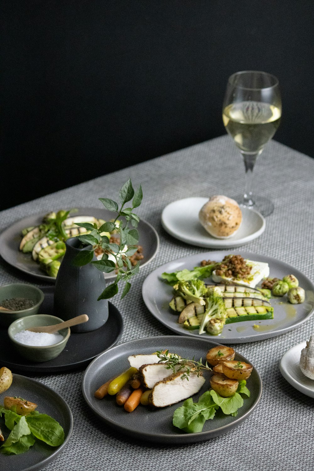 a table topped with plates of food and a glass of wine