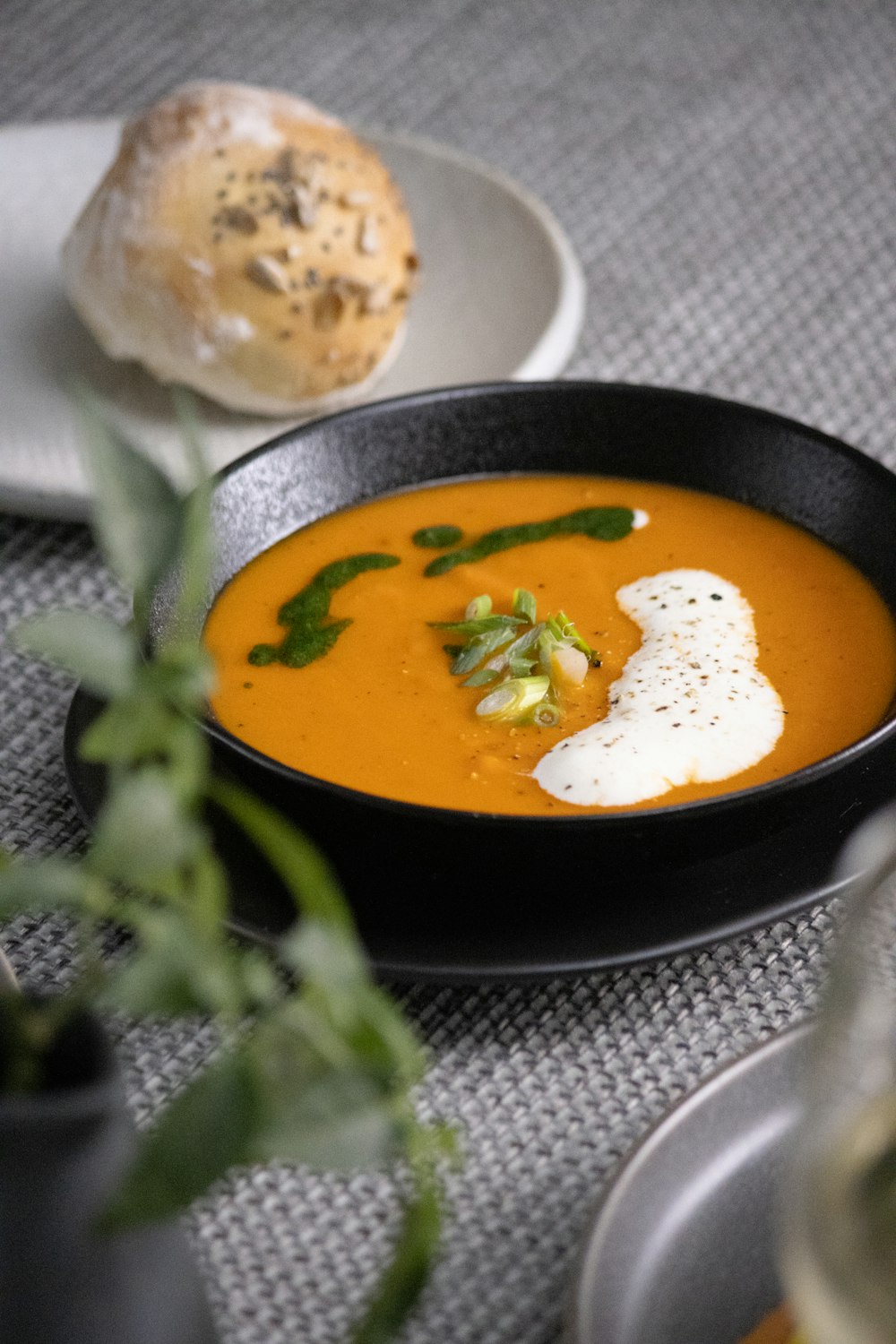 a bowl of soup with a piece of bread on the side