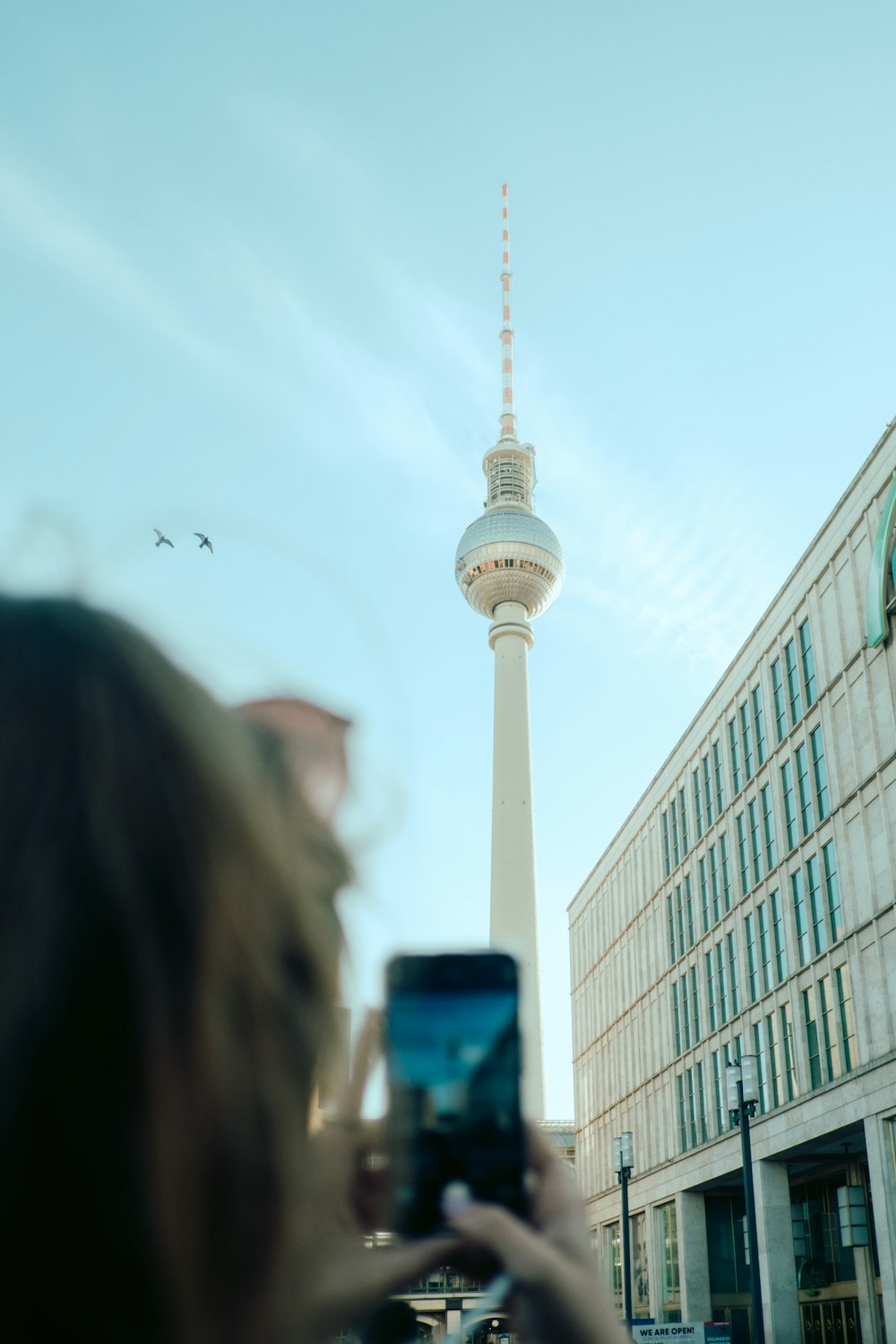 a woman taking a picture of the tv tower