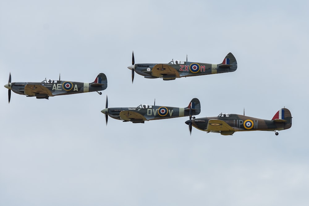 Un gruppo di quattro aerei che volano attraverso un cielo nuvoloso
