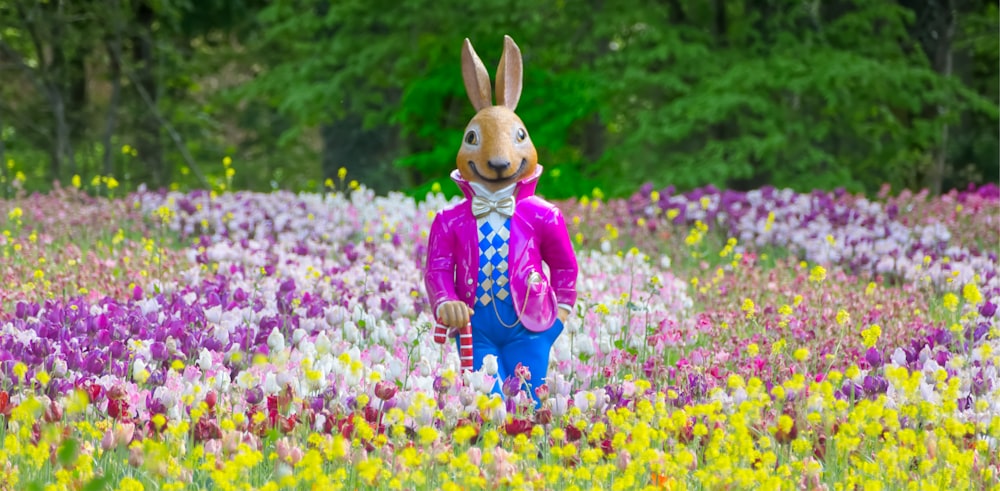 um coelho em um campo de flores com árvores no fundo