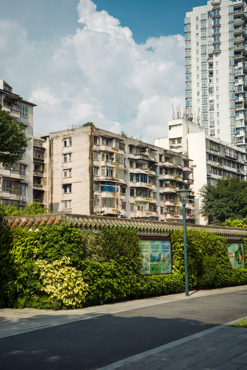 a tall building sitting next to a lush green hedge