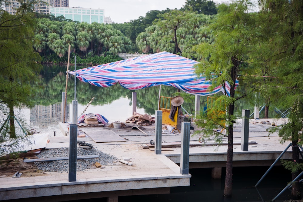 a blue and white striped umbrella sitting on top of a pier