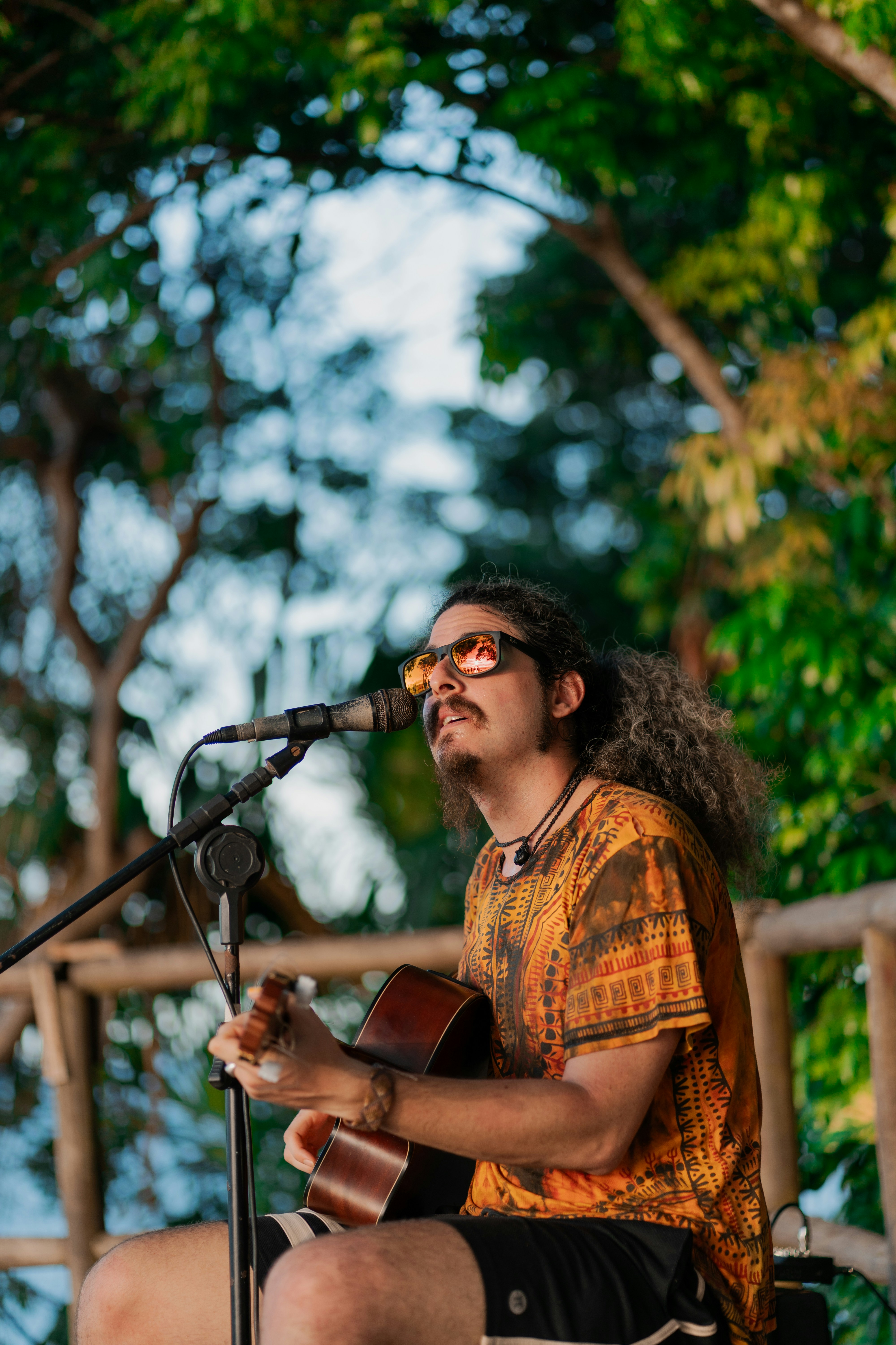 seorang pria duduk di bangku bermain gitar