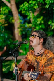 a man with long hair playing a guitar