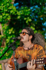 a man playing a guitar while singing into a microphone