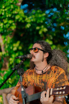 a man playing a guitar while singing into a microphone