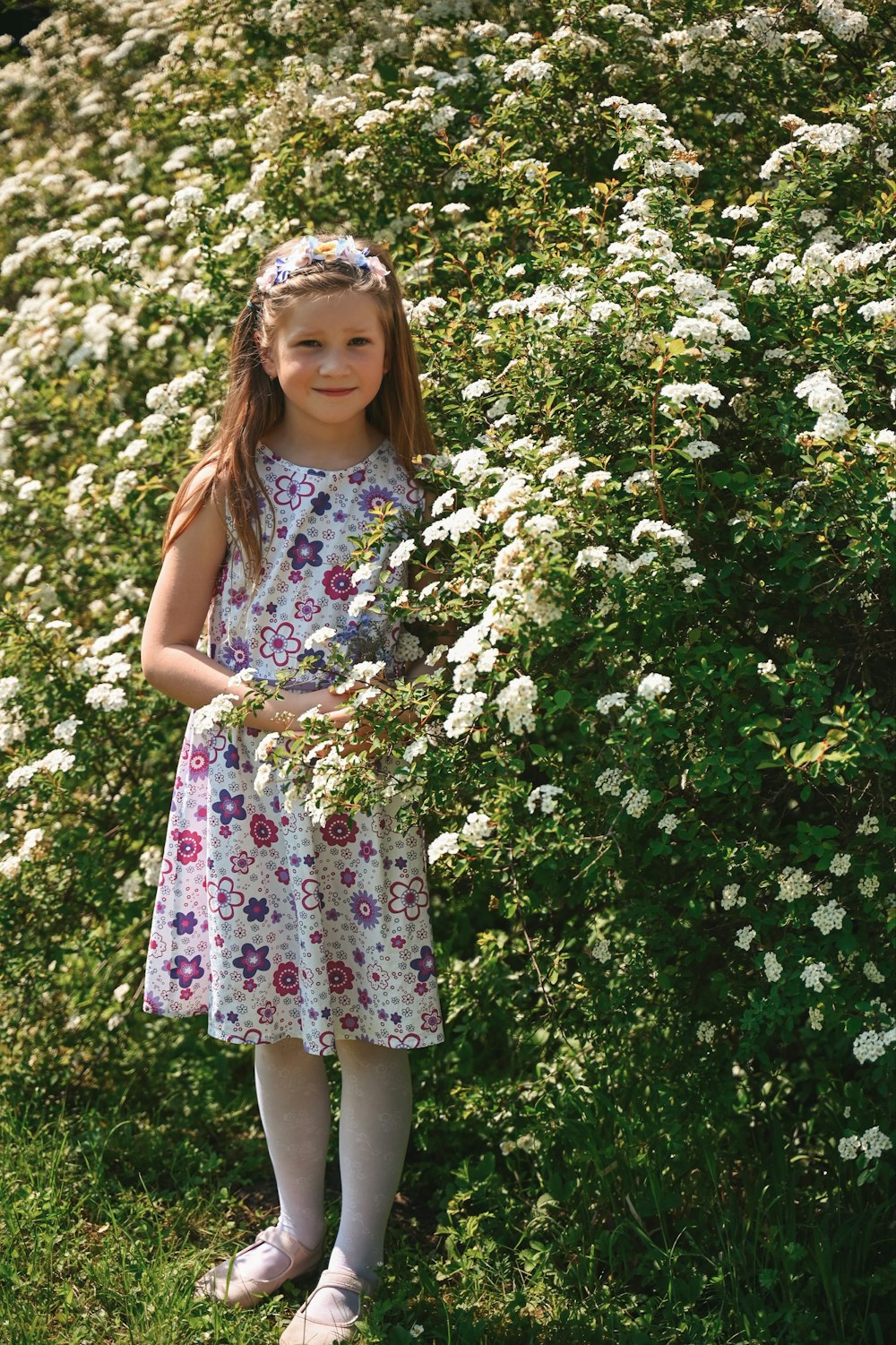 a little girl standing in a field of flowers