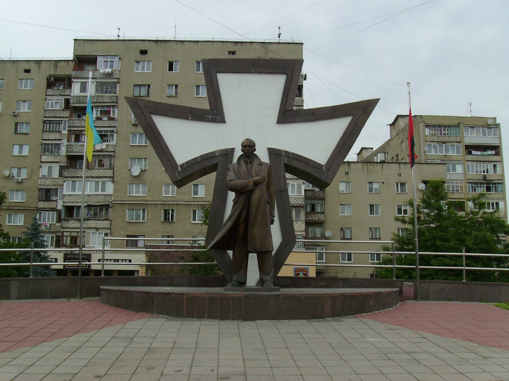 a statue of a man holding a cross in front of a building