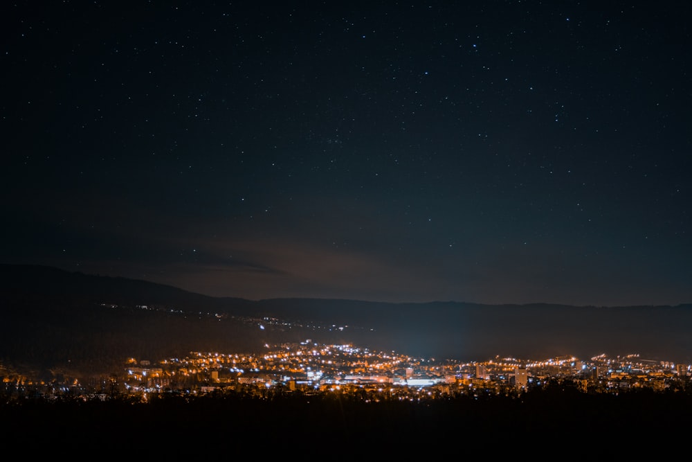 a night time view of a city and mountains