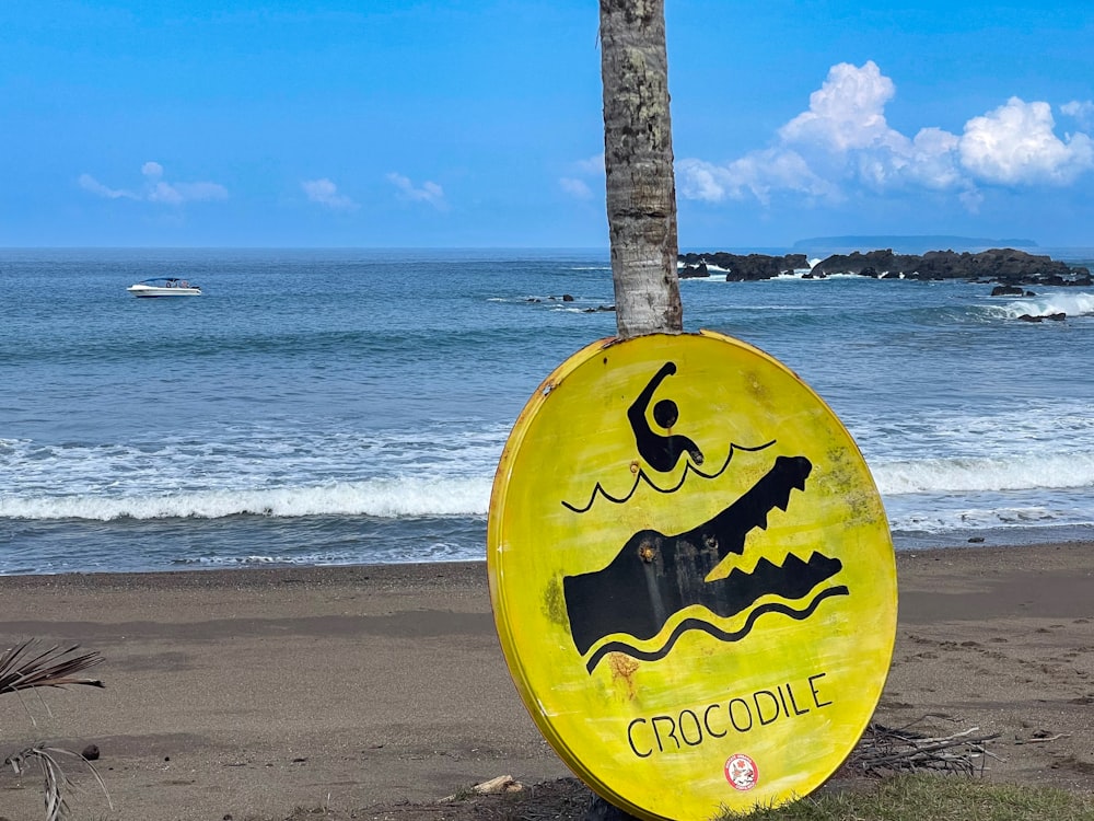 un frisbee amarillo sentado en la parte superior de una playa de arena