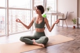 a woman sitting on a yoga mat in a room
