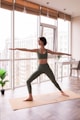 a woman in a yoga pose in front of a window