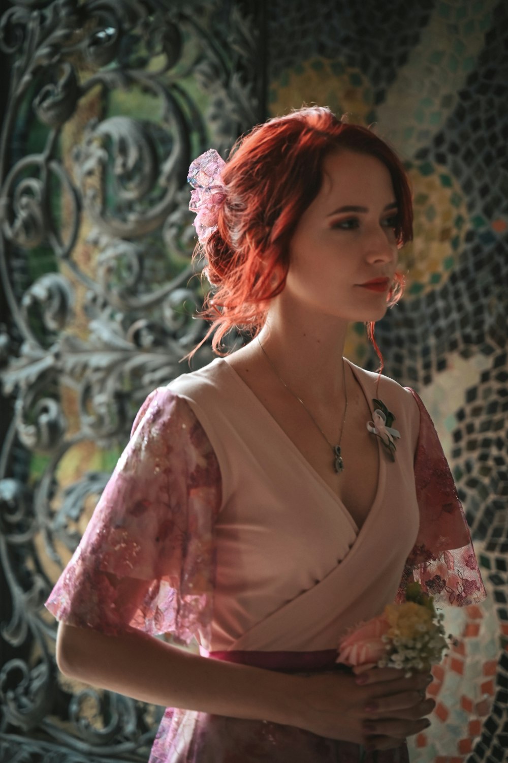 a woman with red hair wearing a pink dress