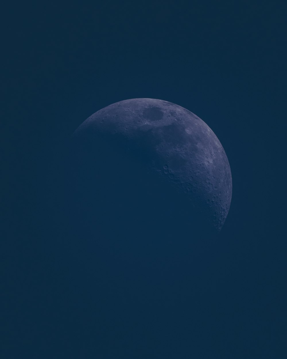 a half moon in a dark blue sky