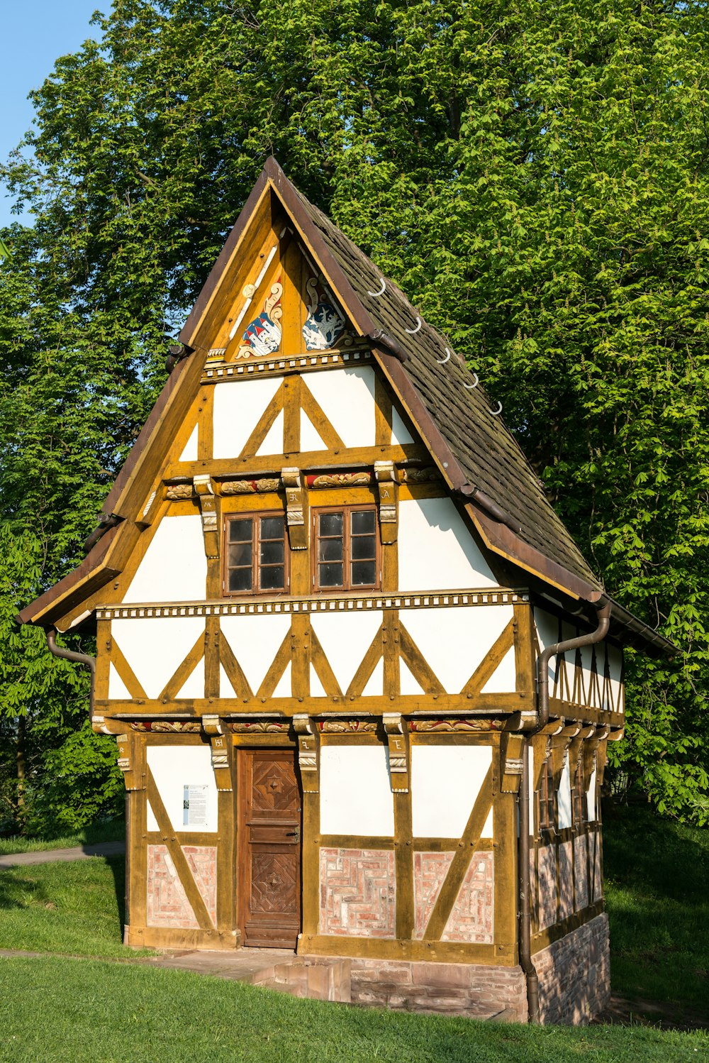 ein kleines Gebäude mit einer Uhr auf dem Dach