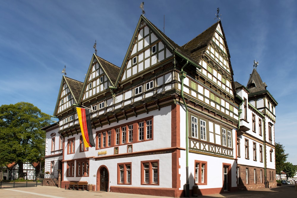 a large white and brown building with a flag on top of it