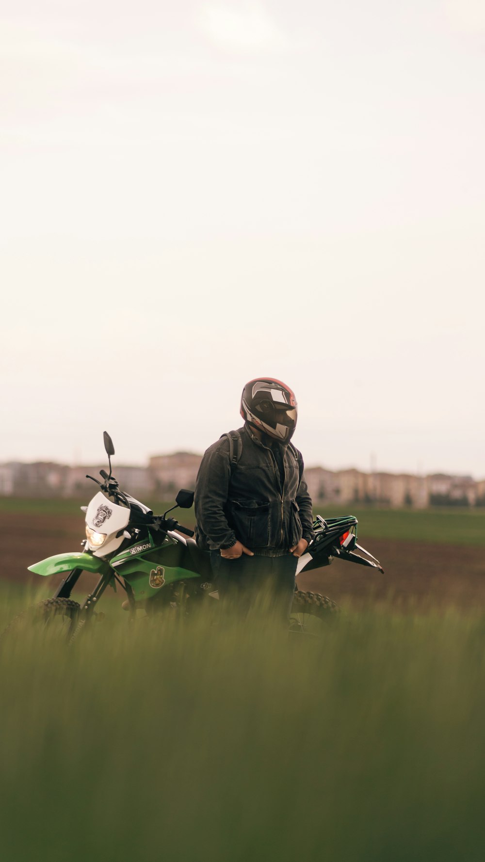 a man sitting on a motorcycle in a field