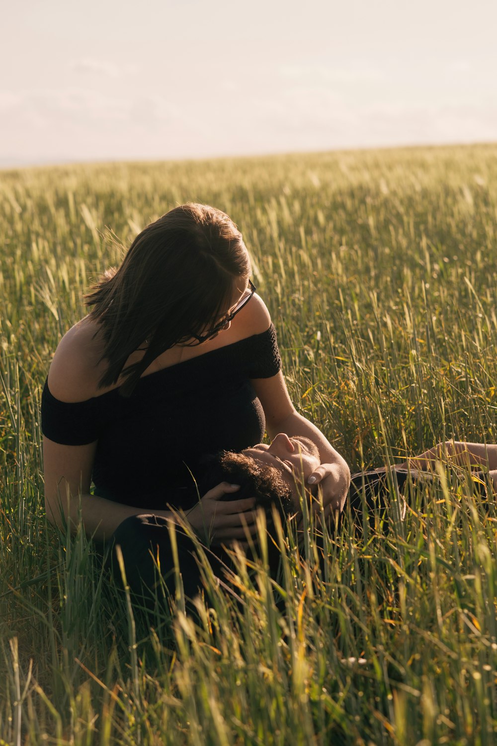 a woman sitting in a field of tall grass