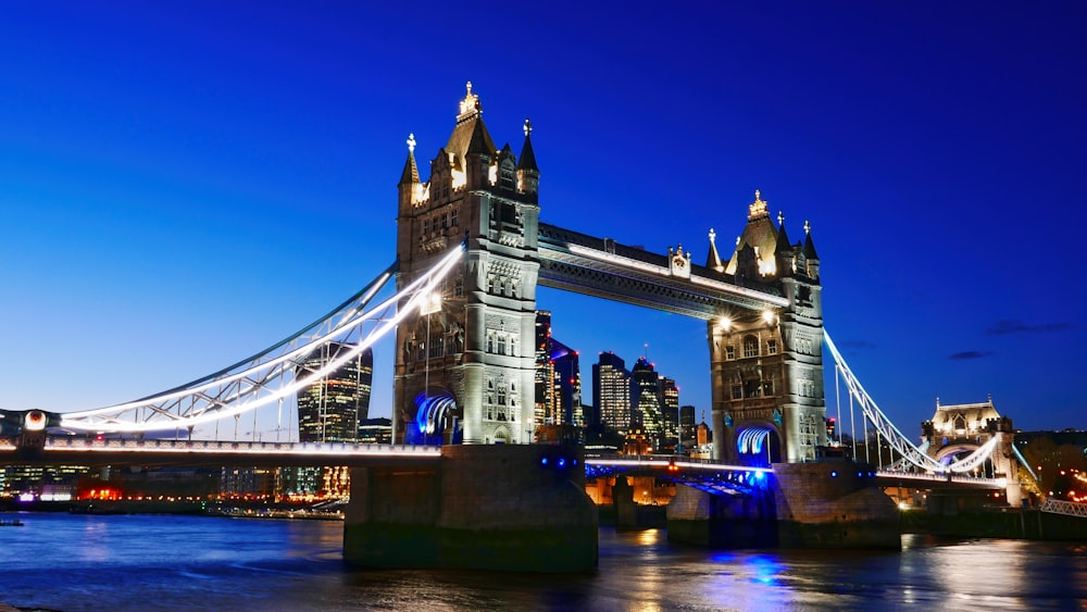 the tower bridge is lit up at night