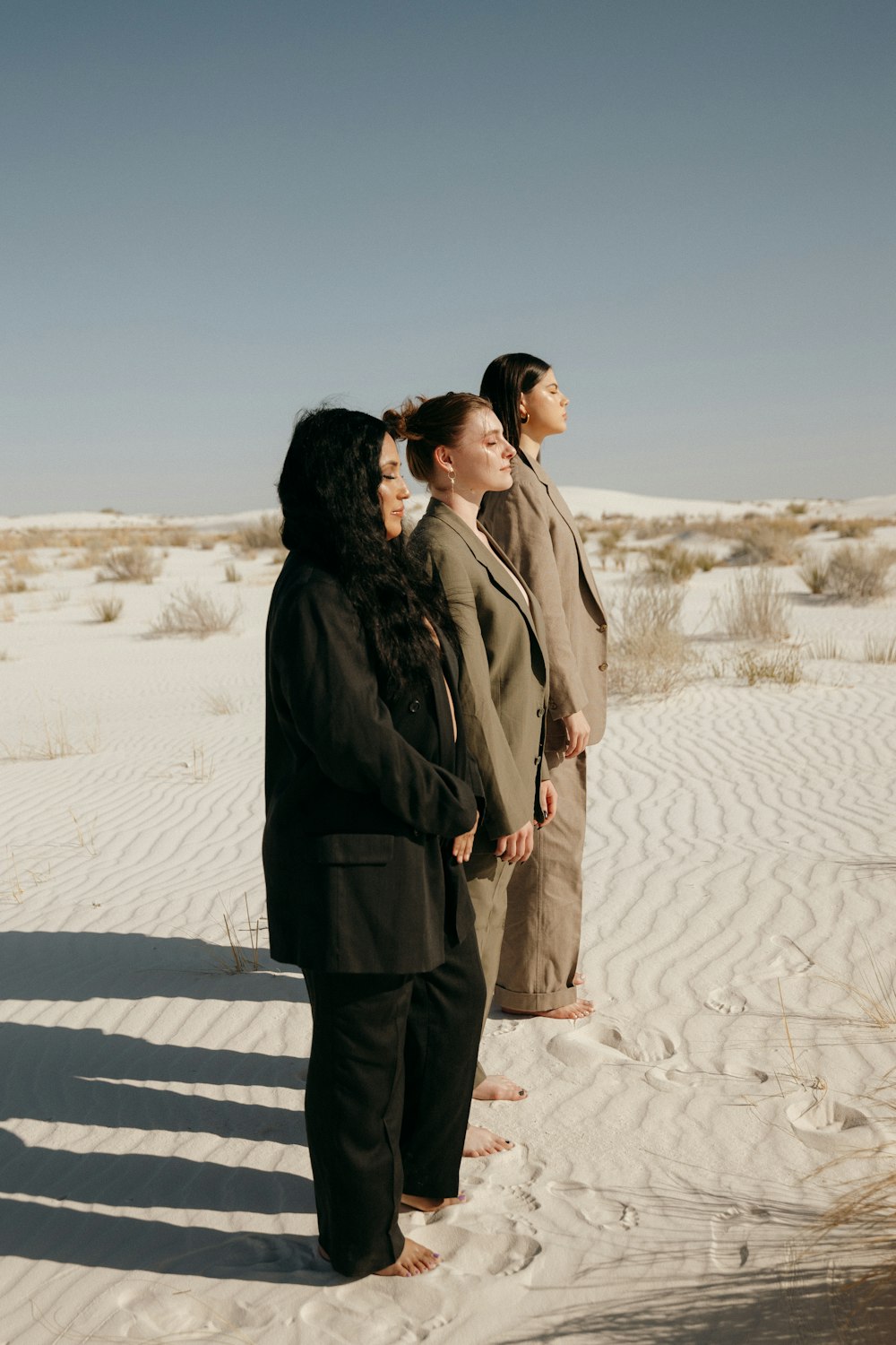 a group of people standing on top of a sandy beach