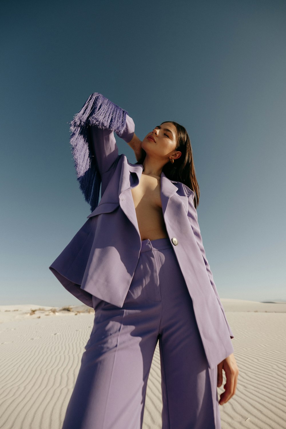 a woman in a purple suit standing in the desert