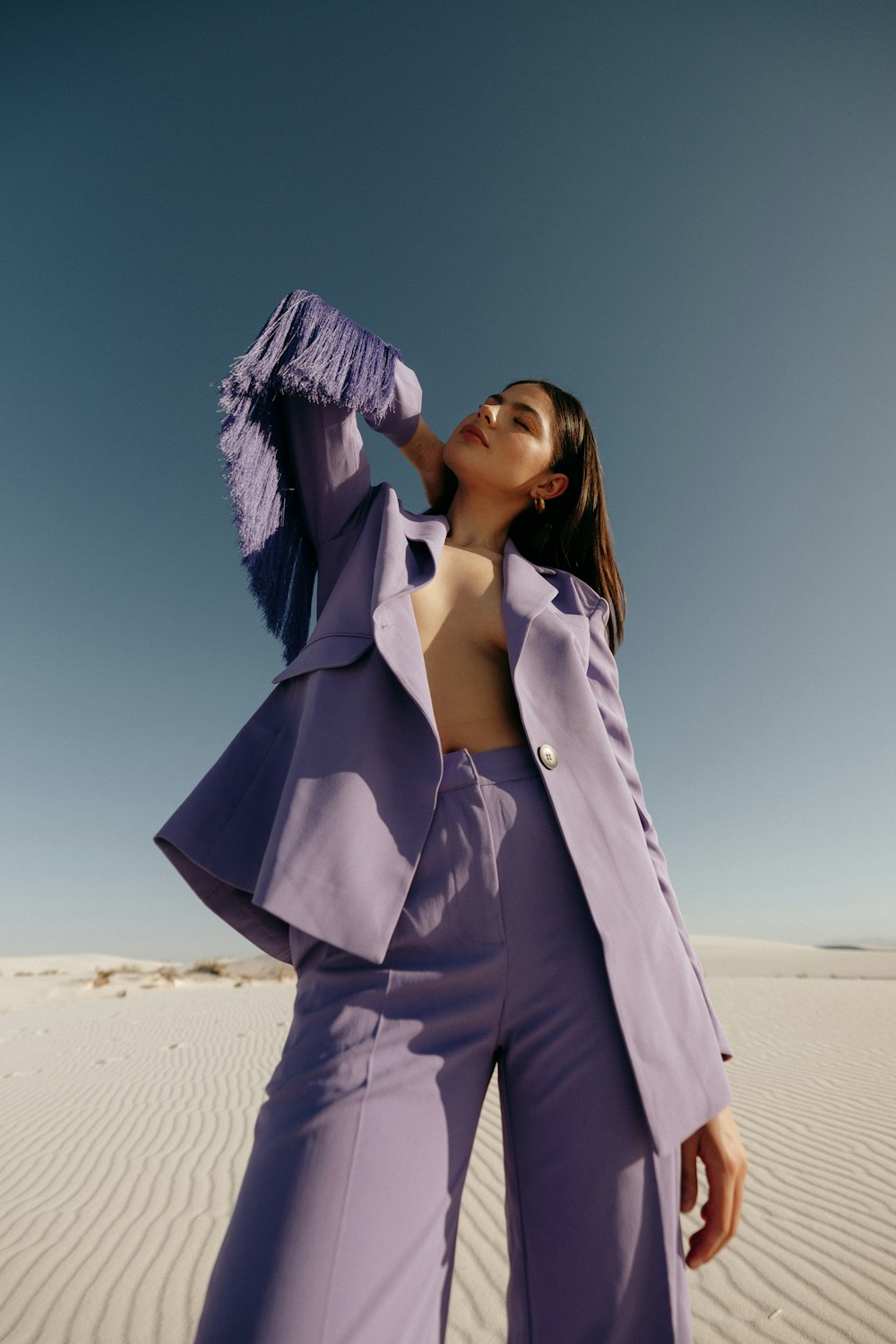 uma mulher em um terno roxo em pé no deserto